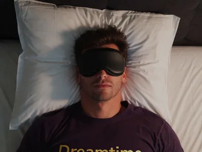 Person relaxing in bed with sleep mask